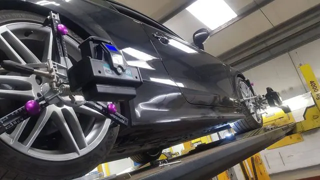 Wheel alignment equipment fitted to a black car at MVM Garage Bridlington